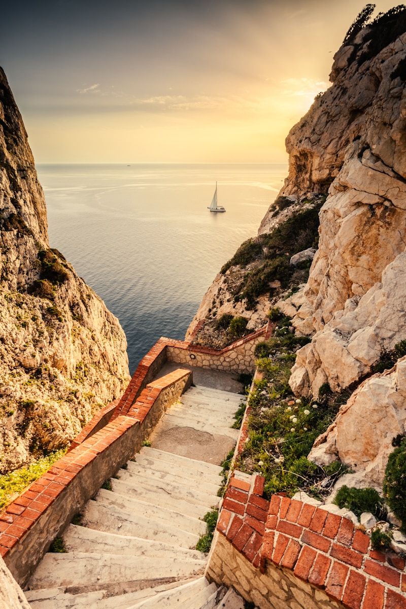 a stairway leading to a boat in the ocean - Sardinia Travel Guide, Italy