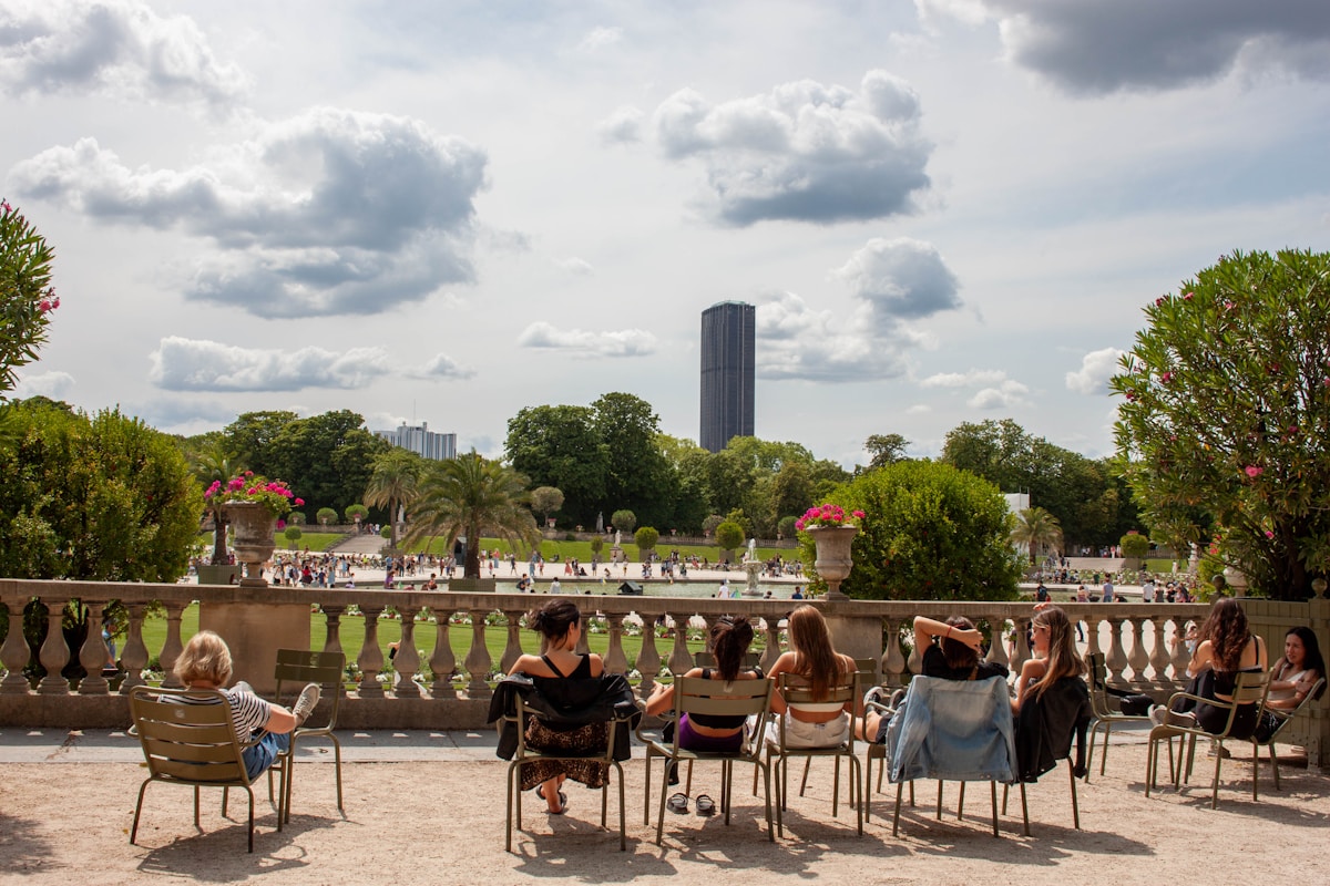 a group of people sitting on chairs in a park - event in Paris