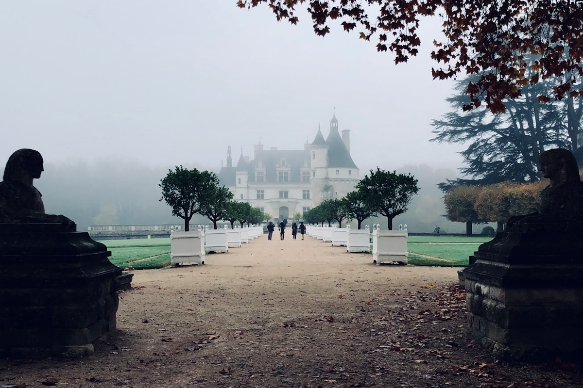 Loire Valley France - four person walking towards concrete house during foggy daytime