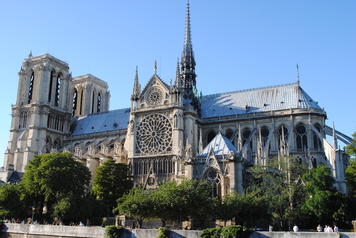 a large cathedral with a clock on the front of it - Notre-Dame de Paris