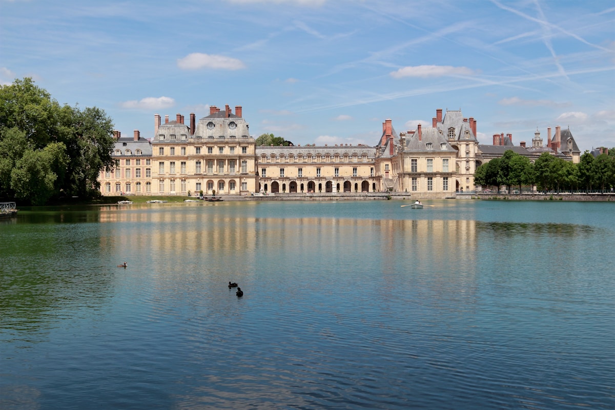 Château de Fontainebleau - white concrete building near body of water during daytime