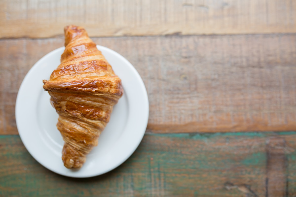 baked pastry on white ceramic saucer - Croissant Paris