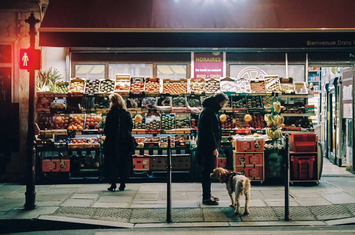 man in black jacket standing in front of food stall - food and wine guide Paris