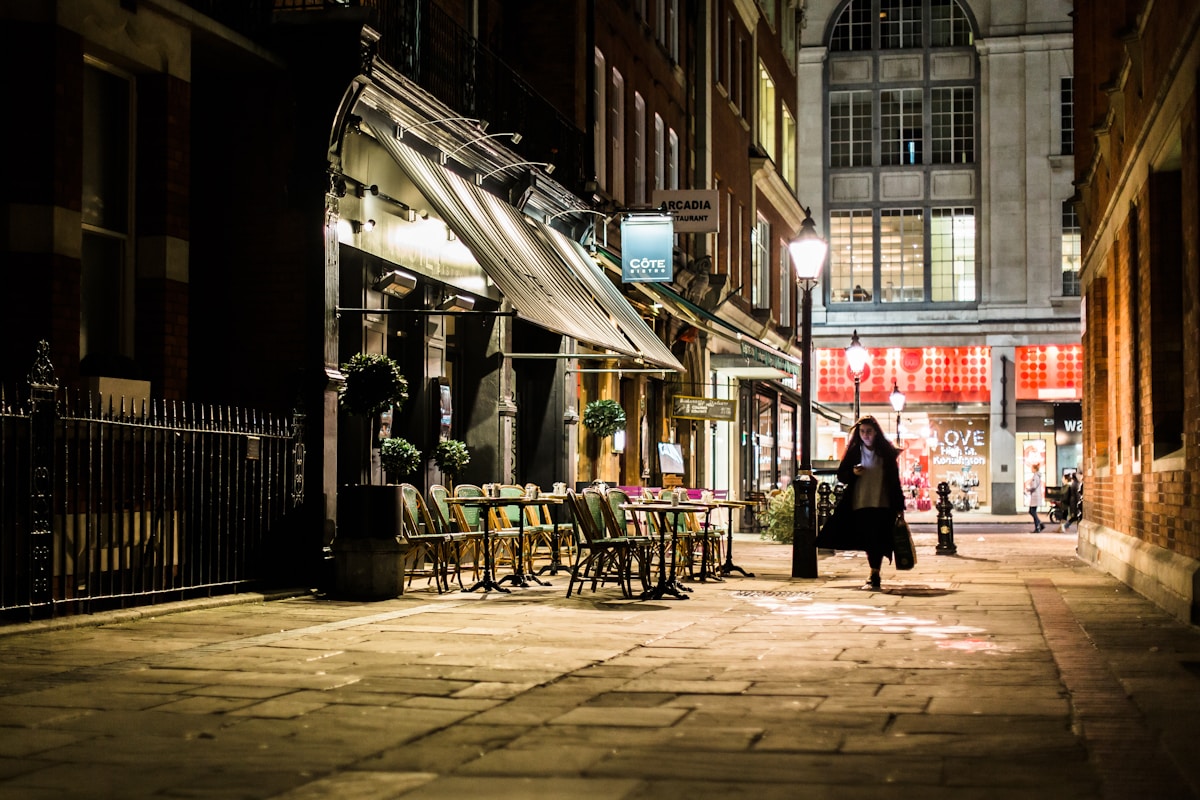 woman walking in alley near white store - Shopping in London