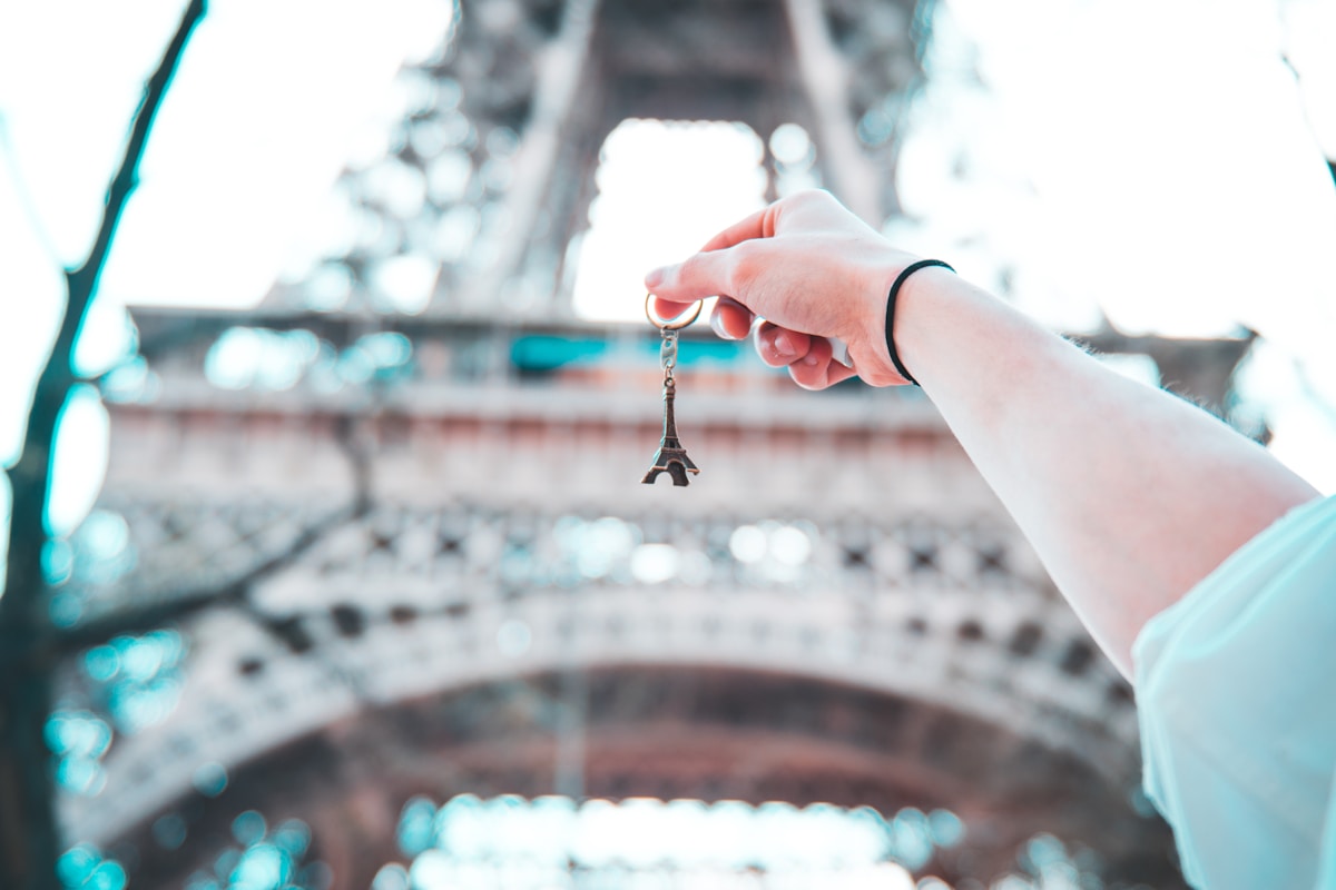 person holding Eiffel Tower keychain - day trips from Paris