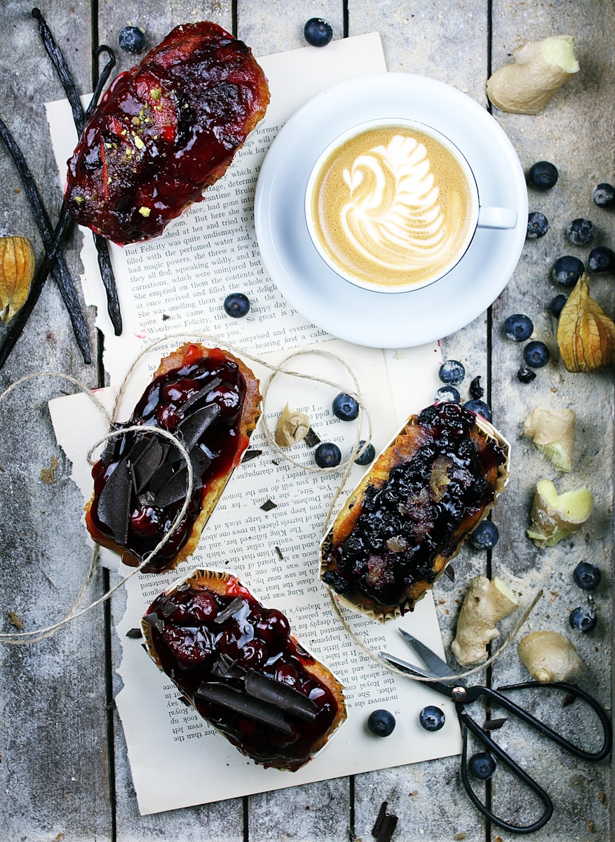 fruit cakes, cappuccino and blueberries on gray wooden panel - London Food