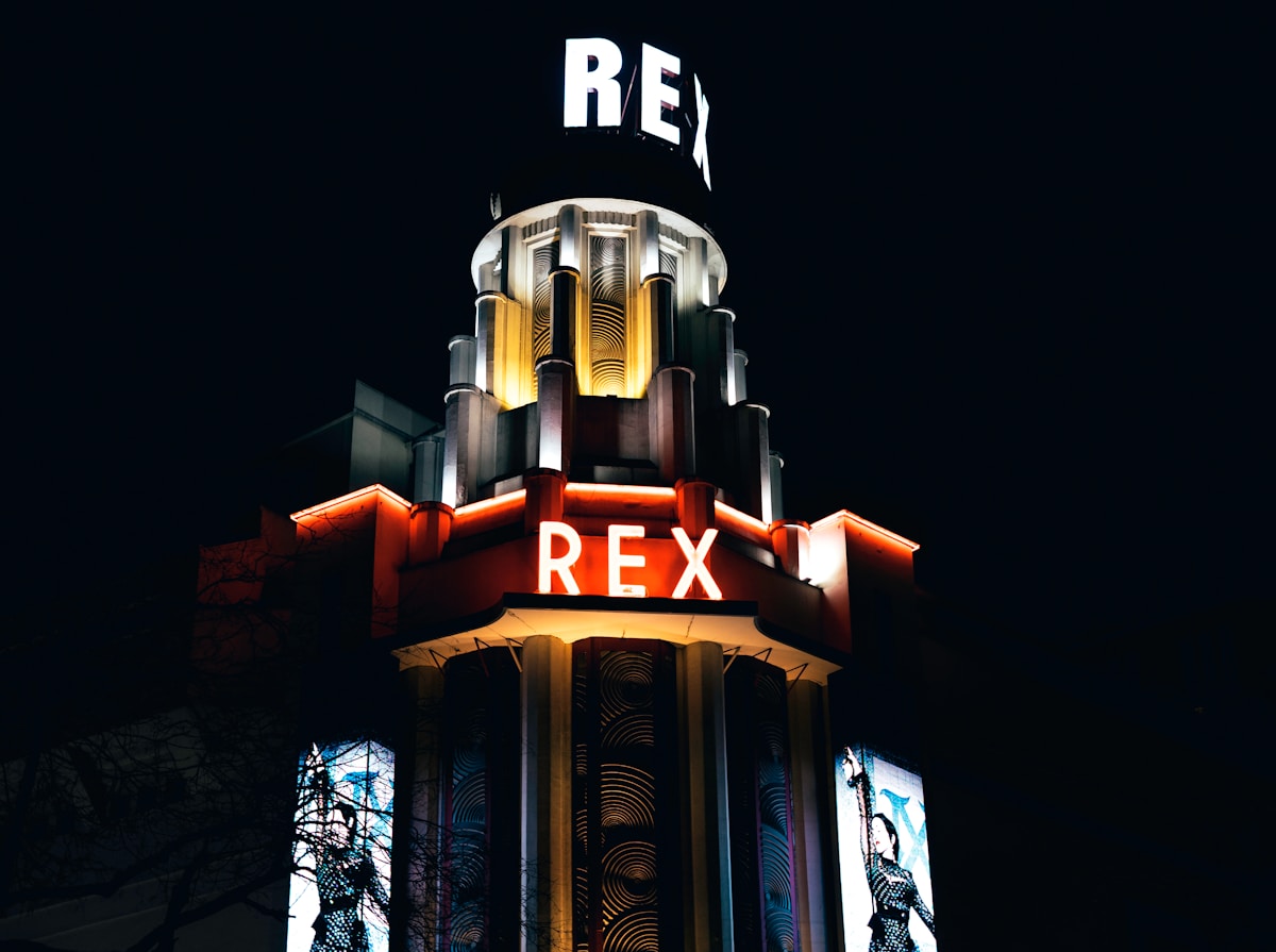 white and red concrete building during nighttime - Le Grand Rex