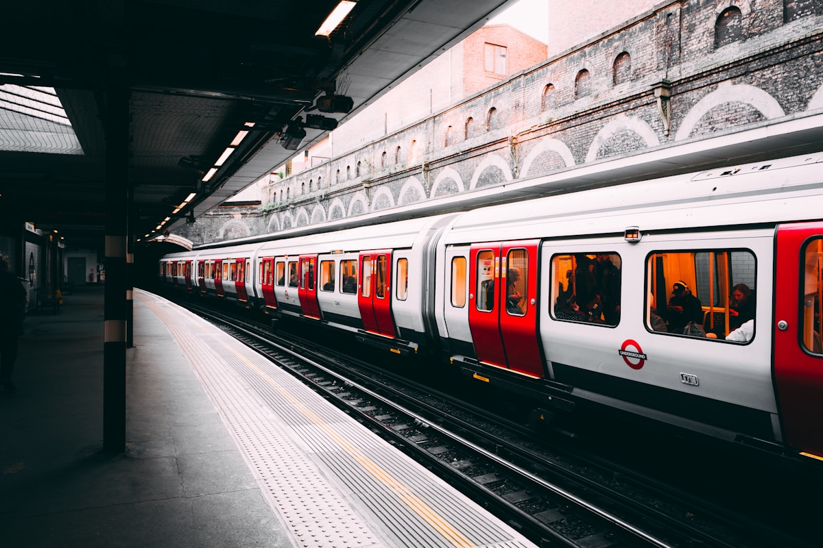 white and red train beside building at daytime - London Hidden Gems, London Transportation