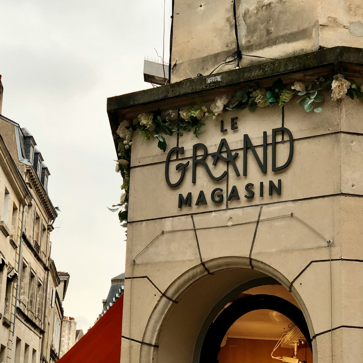 a sign on the side of a building that says grand magasin - Grand Magasins