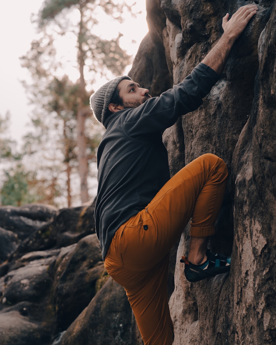 a man climbing up the side of a mountain - day trips from Paris