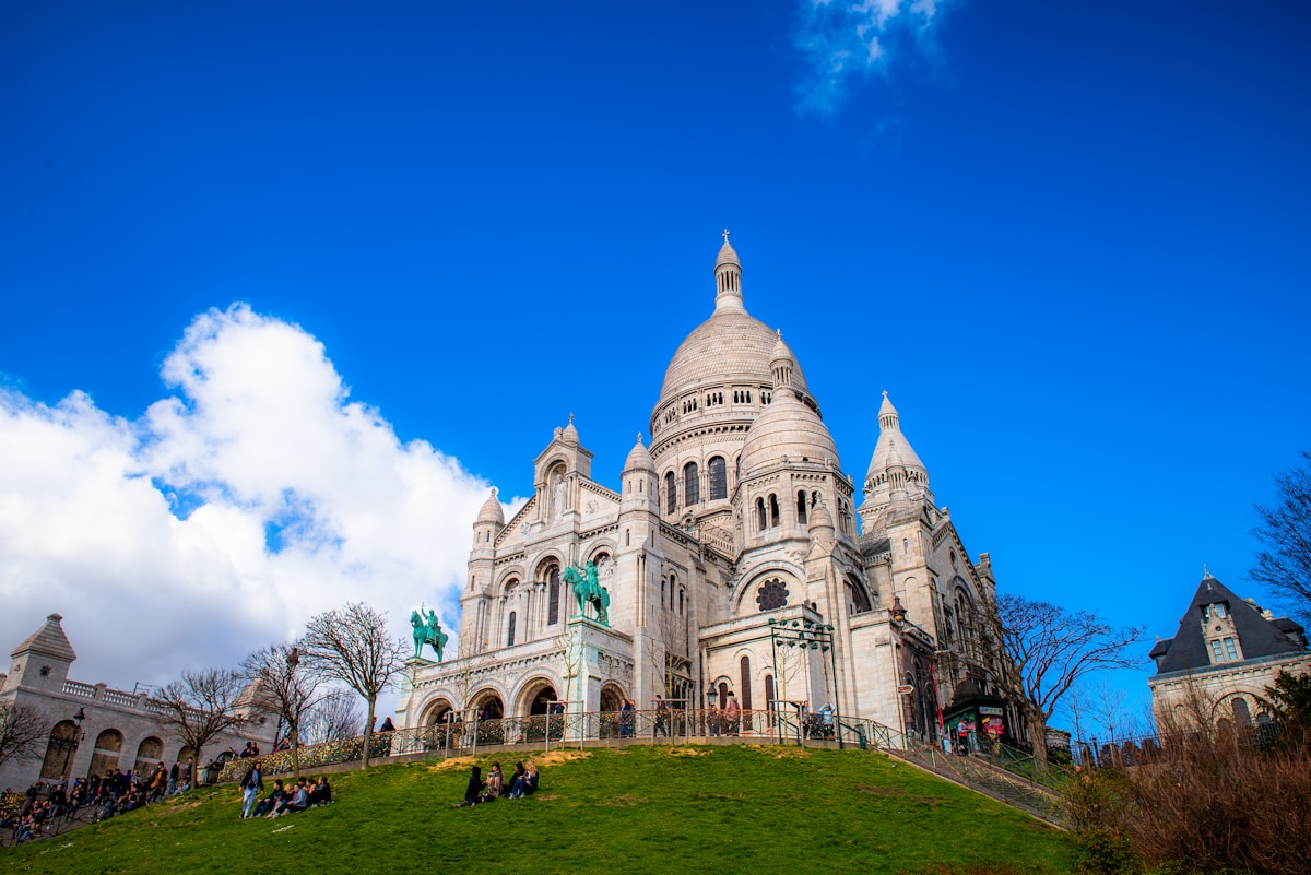 a large building with a steeple on top of a hill - Sacré-Coeur Basilica Paris