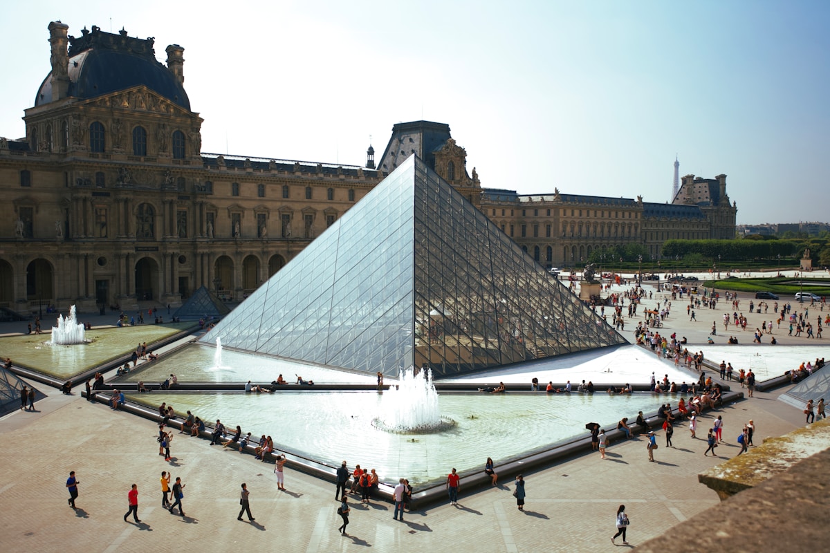 people walking around pyramid landmark - event in Paris