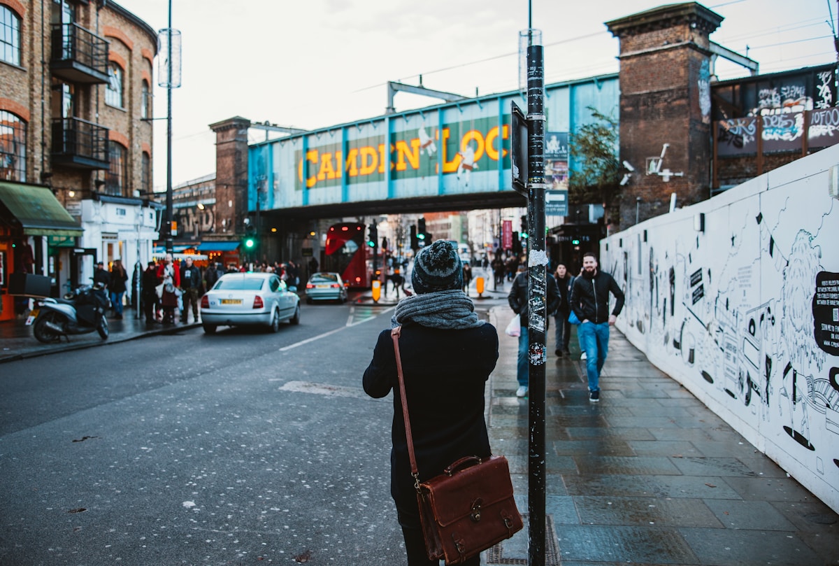 people walking on black concrete road beside buildings under white sky during daytime - where to stay in London