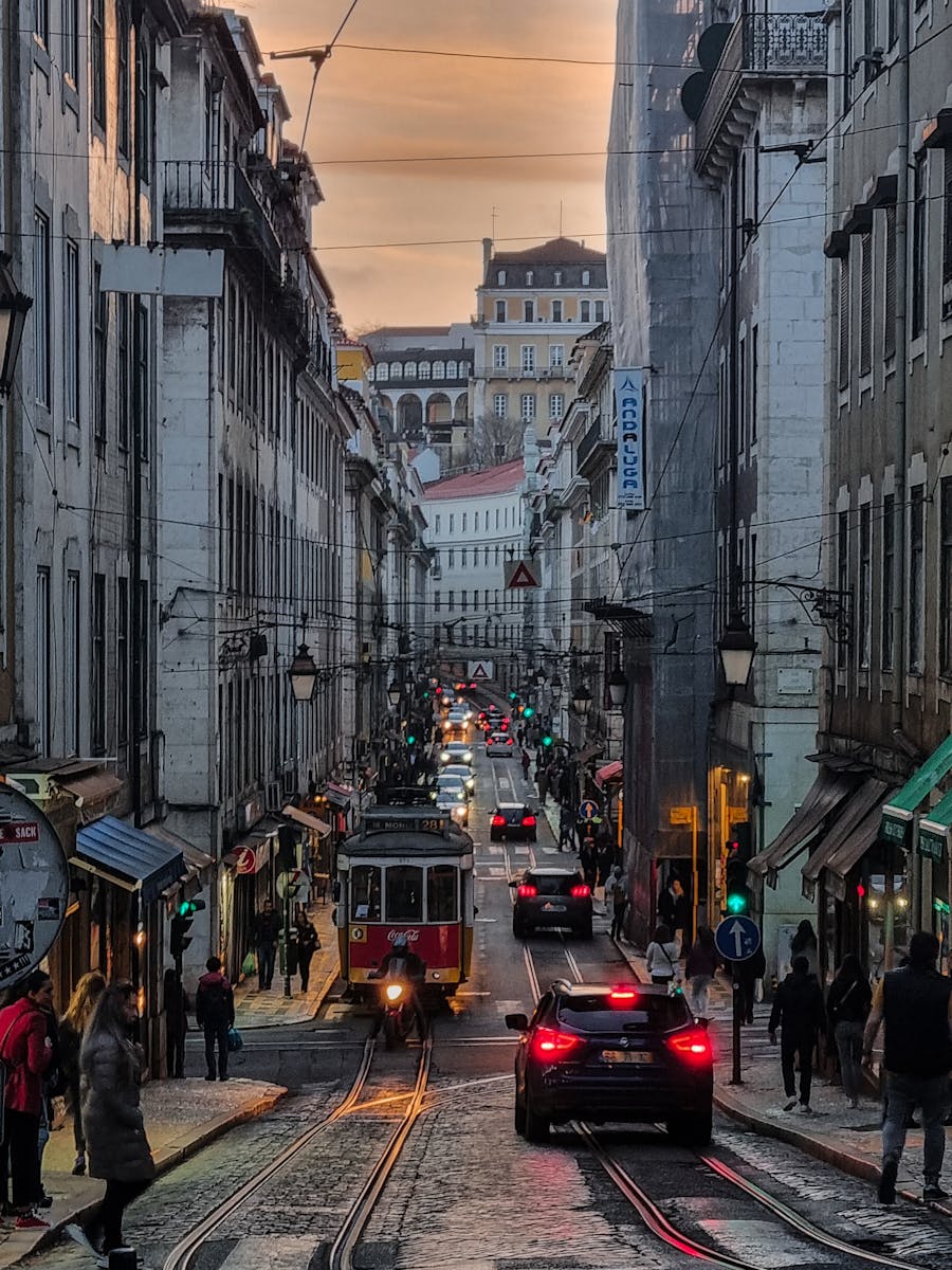 Charming street scene in Lisbon with historic tram and vibrant city life at dusk - Mouraria narrow streets in Lisbon, Portugal