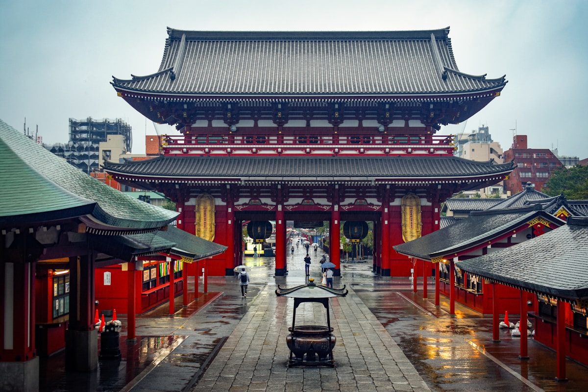 a large building with a lot of red and yellow buildings - Sensō-ji Temple Tokyo