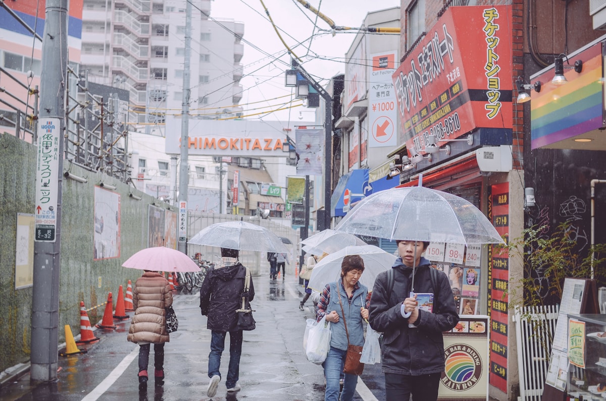 a group of people walking down a street holding umbrellas - Shimokitazawa, Kitazawa, Setagaya City, Tokyo, Japan