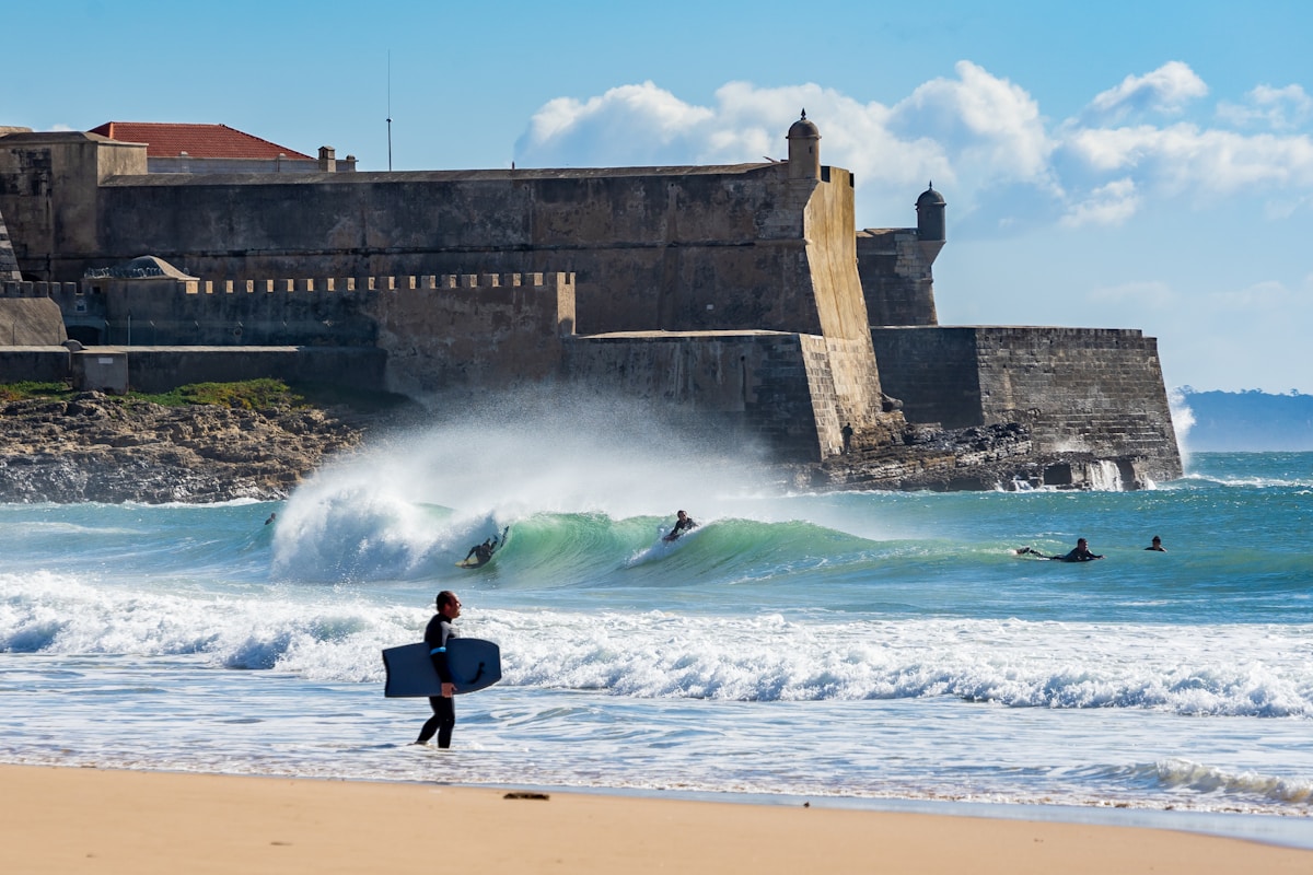 people surfboarding on beach near fort - Carcavelos Beach, Lisbon, Portugal