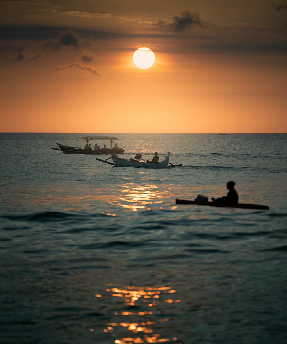 silhouette of 2 people riding on boat during sunset in Uluwatu, Bali