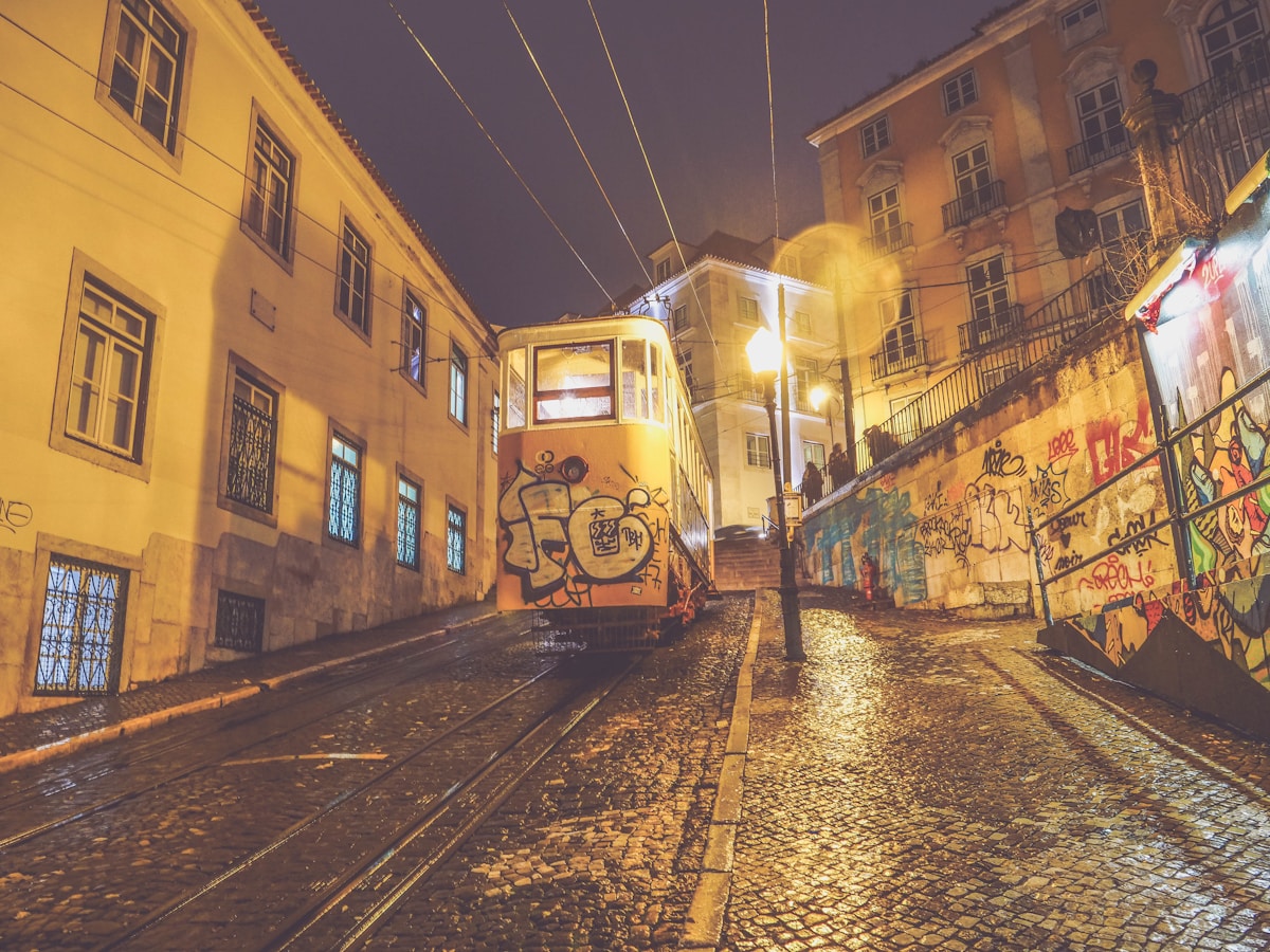 orange train on black road - Bairro Alto Lisbon Portugal