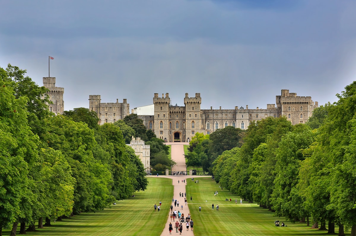 Windsor Castle - people walking on green grass field near brown concrete building during daytime