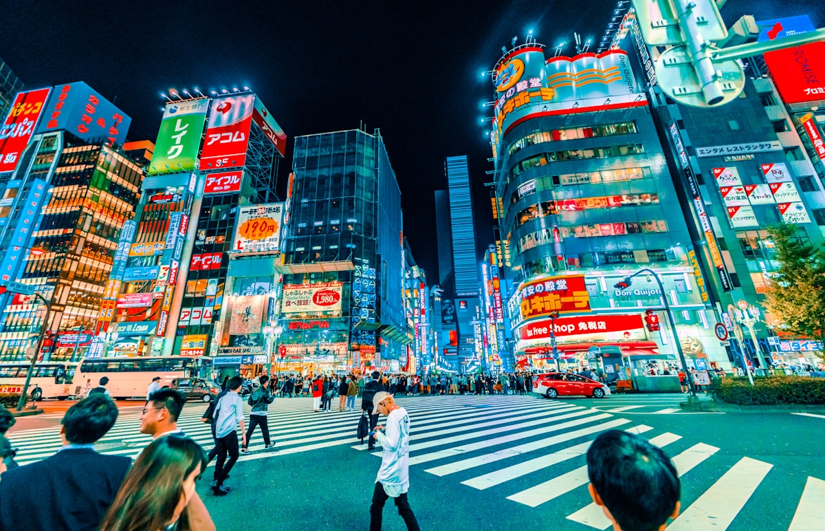 people crossing pedestrian near buildings at night - Things to do in Tokyo -Shinjuku Shopping