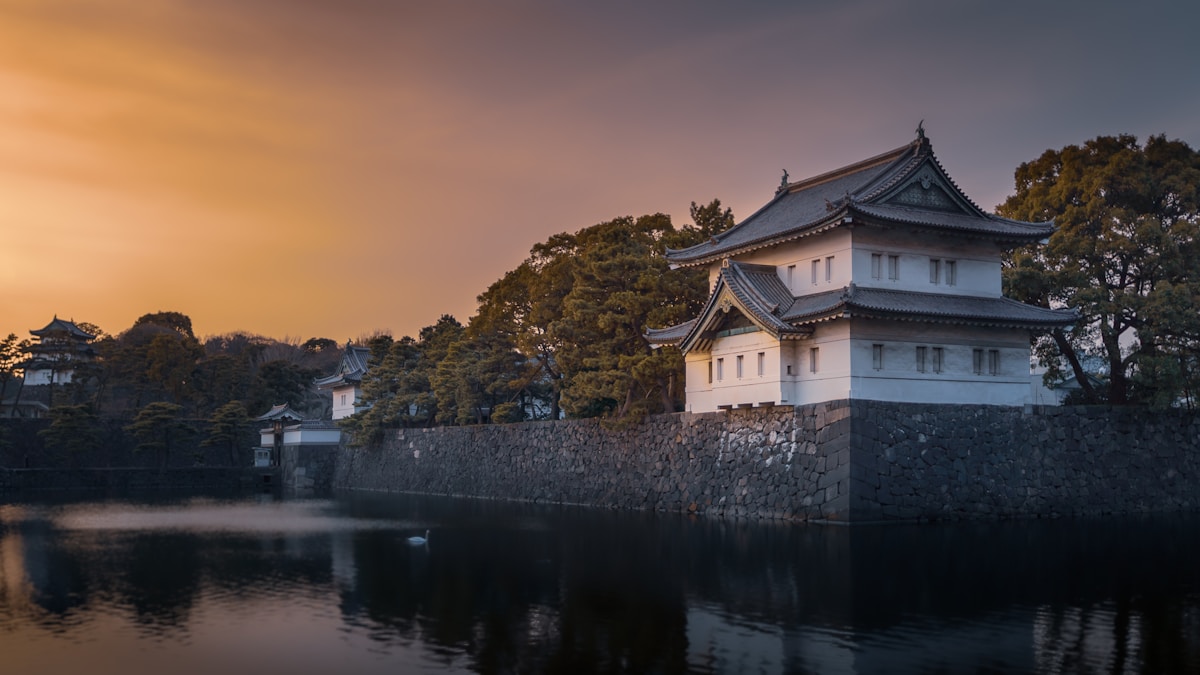 a building on a hill by a body of water - Tokyo Imperial Palace