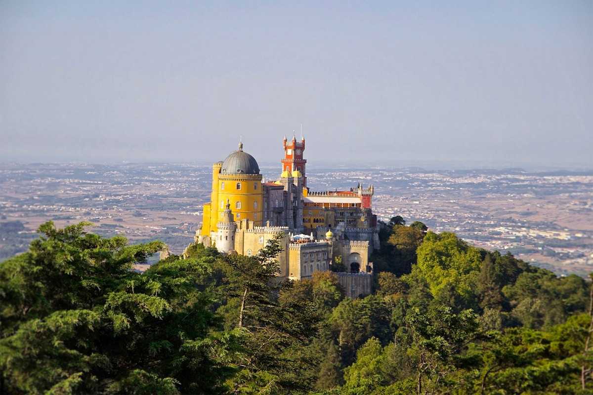 gray and yellow castle at the top of a hill - Palácio da Pena, Sintra, Portugal