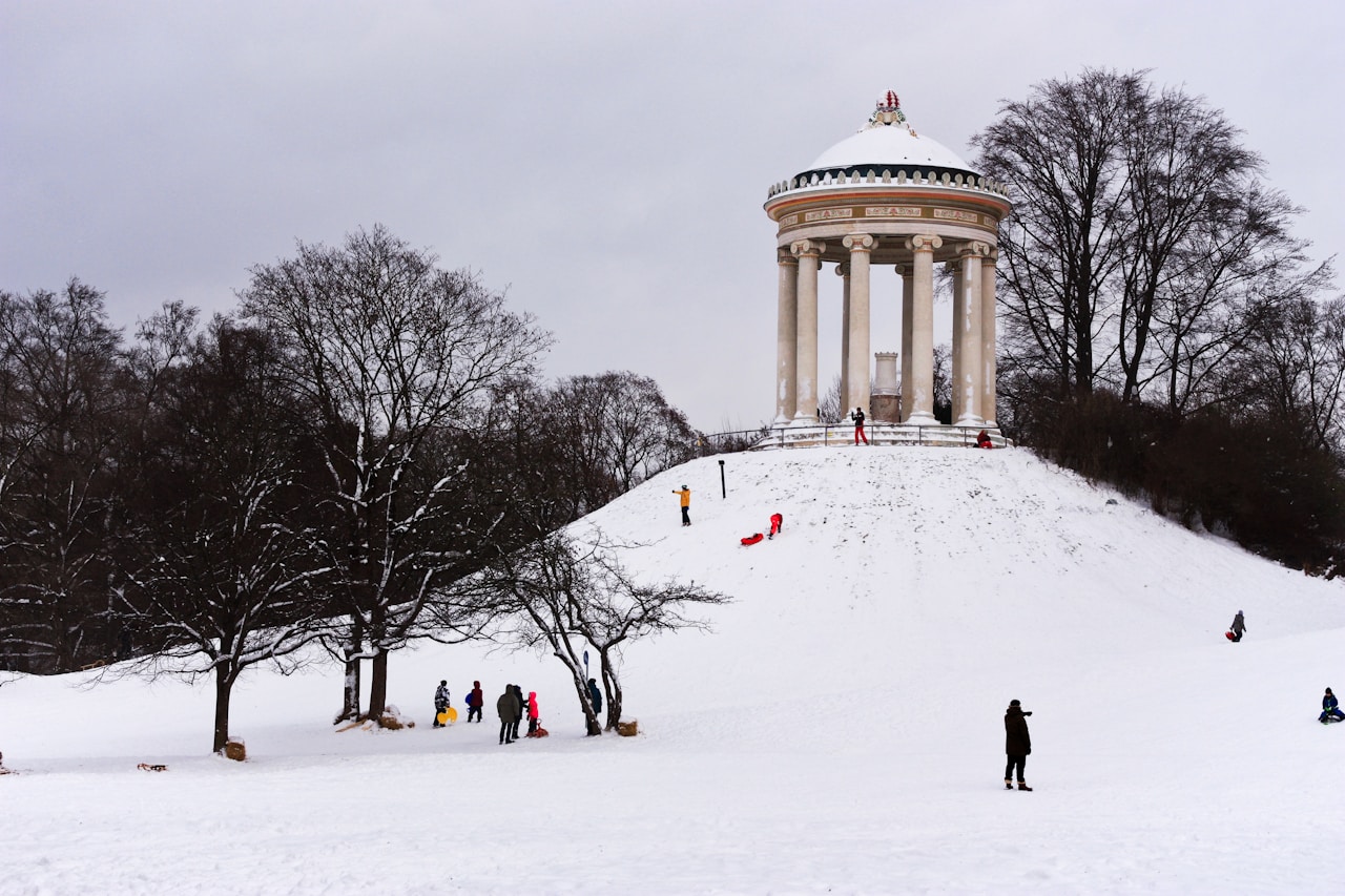Best Day Trips From Munich, a group of people standing on top of a snow covered slope