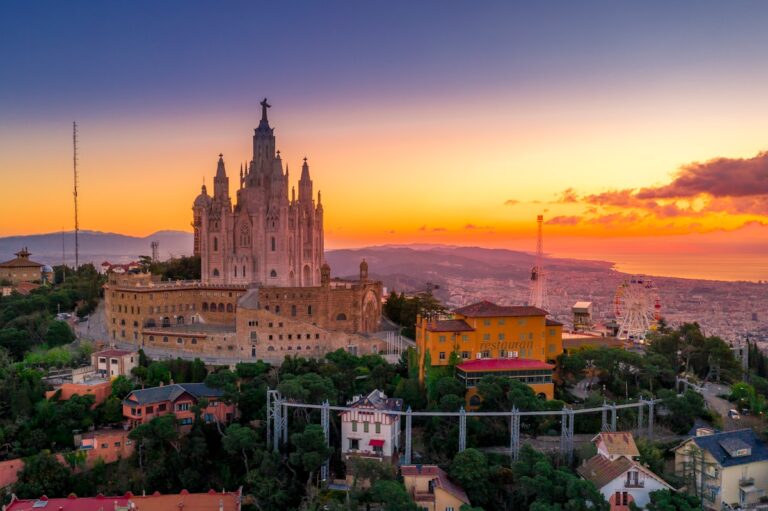 "Sunset view of the iconic Sagrat Cor church in Barcelona, surrounded by lush trees and vibrant cityscape."