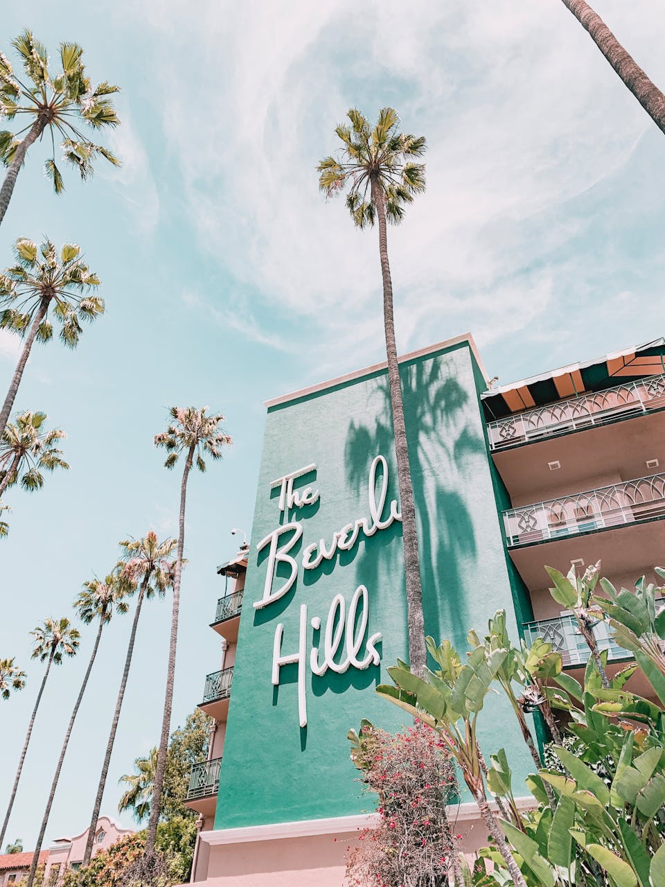 The Beverly Hills Hotel with palm trees under a clear sky. Iconic luxury in Los Angeles, California.
