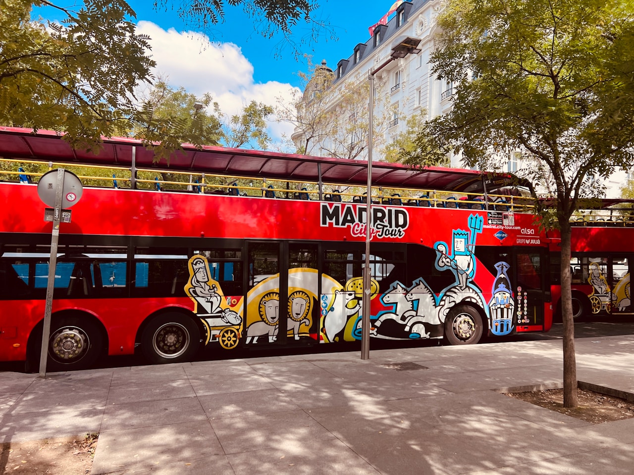 A red double decker bus parked on the side of the road