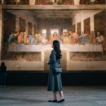 Kannaya Nareswari admiring Leonardo da Vinci's "The Last Supper" mural in a serene museum setting, surrounded by other visitors.