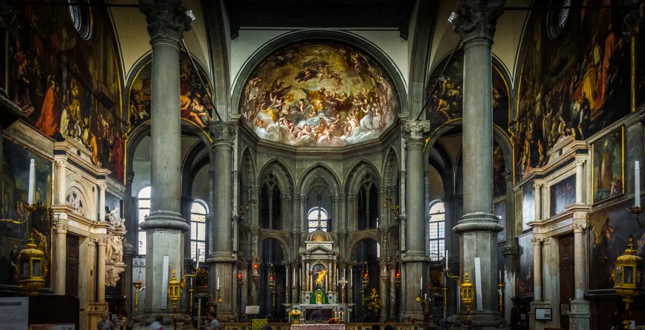 Renaissance San Zaccaria Venice interior featuring intricate frescoes, towering columns, and a prominent altar setting the spiritual ambiance.