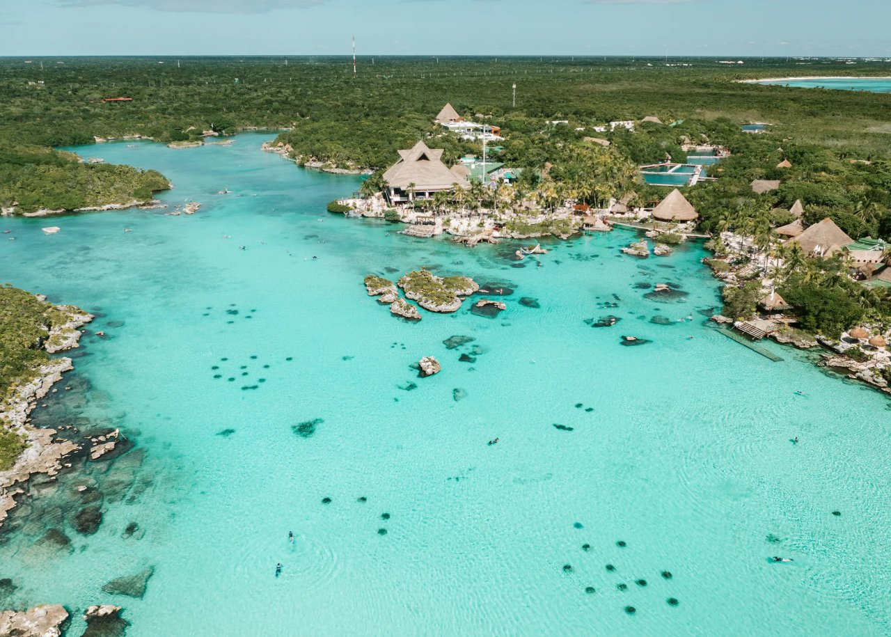 Aerial view of a serene turquoise lagoon surrounded by lush greenery and tropical resorts, perfect for eco-tourism and relaxation.