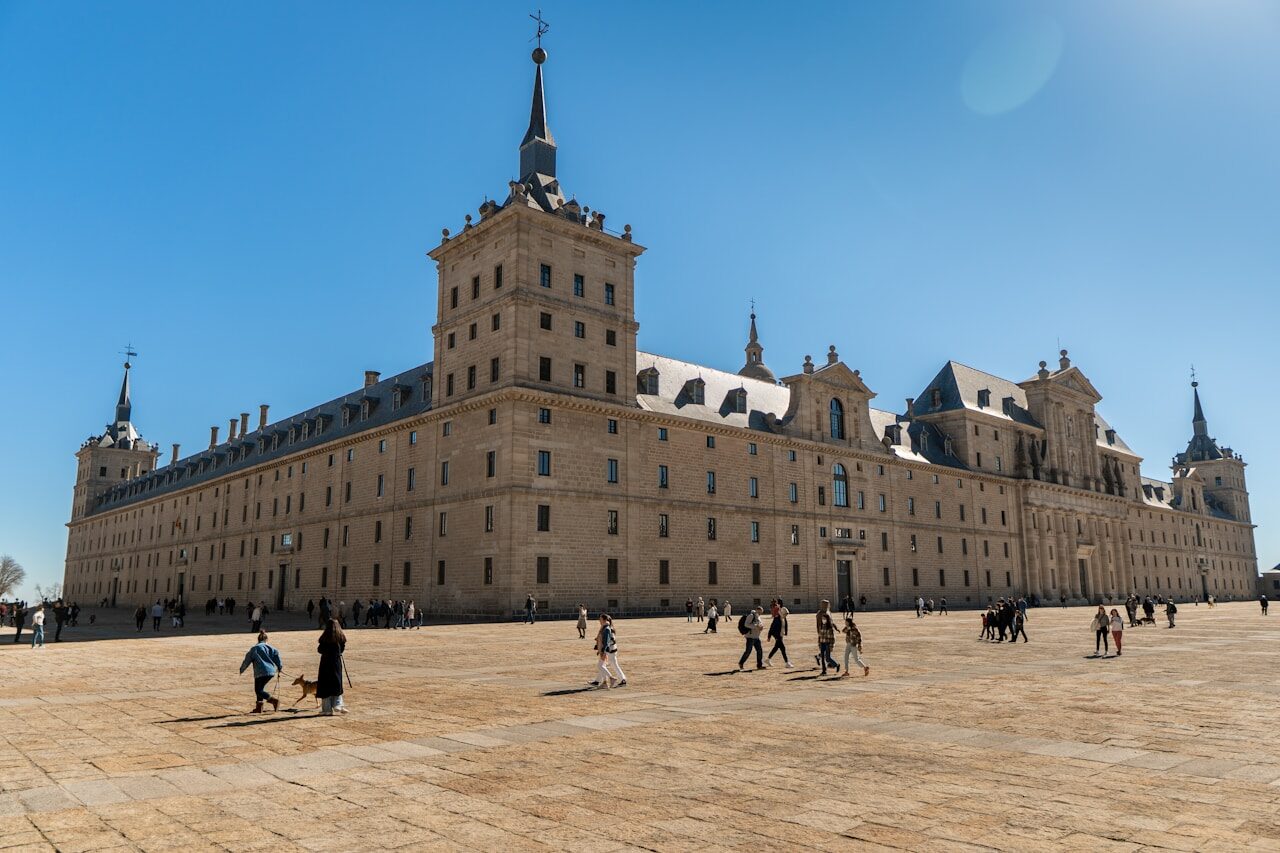 a group of people walking around in front of a large building