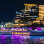 Bangkok Chao Phraya cruise boat illuminated at night, offering scenic views along the river and vibrant city skyline.