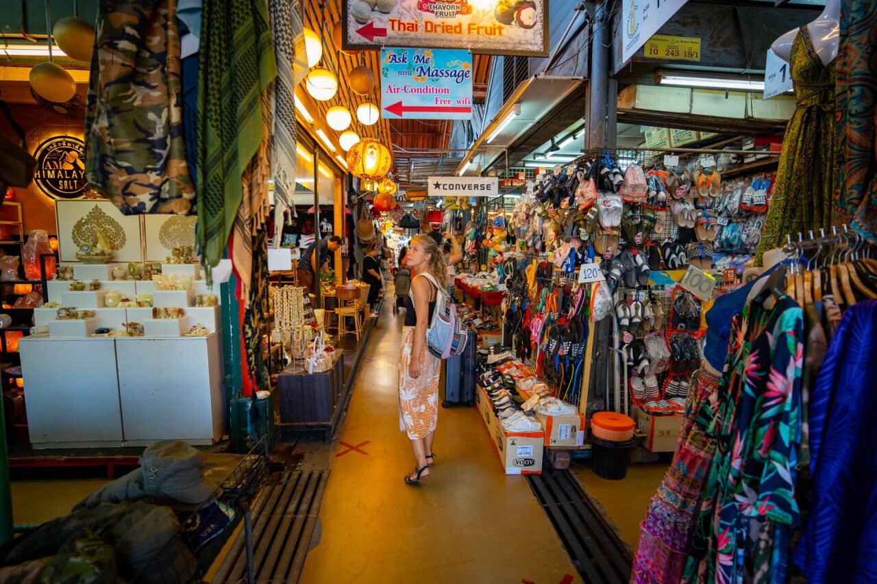 Lively market scene showcasing a variety of colorful shops selling clothing, accessories, and local products in vibrant Bangkok.