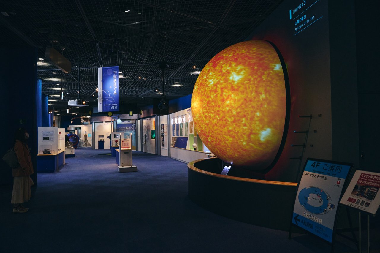 Interactive science exhibit featuring a large, illuminated model of the sun, inviting exploration of solar phenomena.