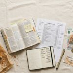 Planning a trip, this flat lay features a budget itinerary, travel expenses, a guidebook, a croissant, and a camera.